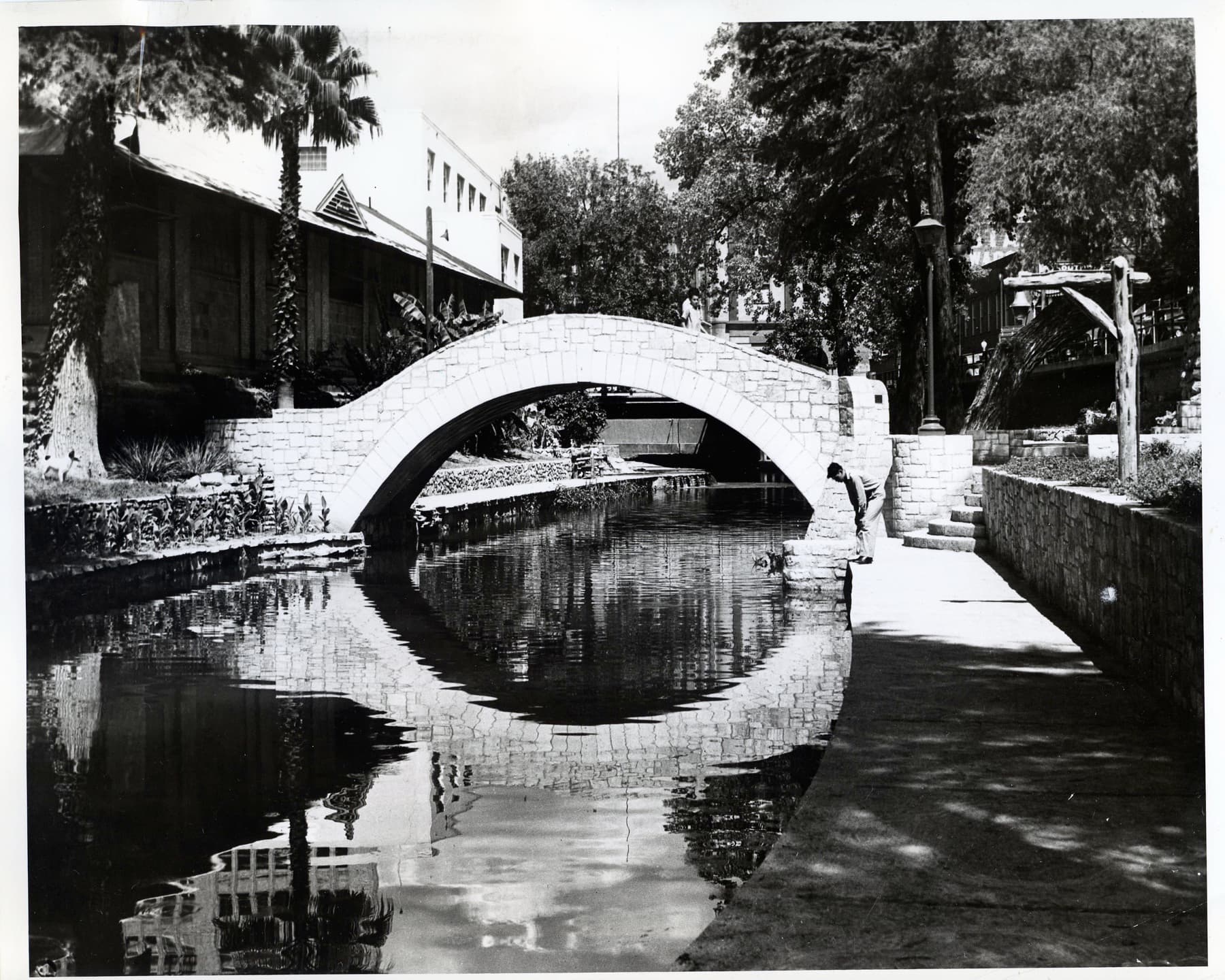Workers building the San Antonio River Walk in 1940 under the federal Work Projects Administration — freshly cut limestone bridge, stairs, and retaining walls realizing Robert Hugman's design.